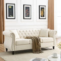 Beige velvet three-seater sofa with rolled-up armrests and rivet decorations; seats 3 people.