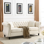 Beige velvet three-seater sofa with rolled-up armrests and rivet decorations; seats 3 people.