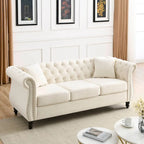 Beige velvet three-seater sofa with rolled-up armrests and rivet decorations; seats 3 people.
