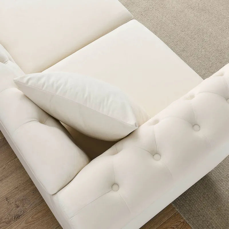 Beige velvet three-seater sofa with rolled-up armrests and rivet decorations; seats 3 people.