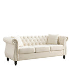 Beige velvet three-seater sofa with rolled-up armrests and rivet decorations; seats 3 people.