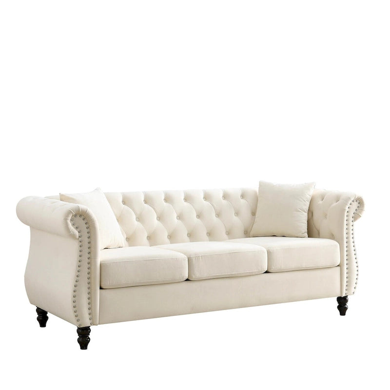 Beige velvet three-seater sofa with rolled-up armrests and rivet decorations; seats 3 people.